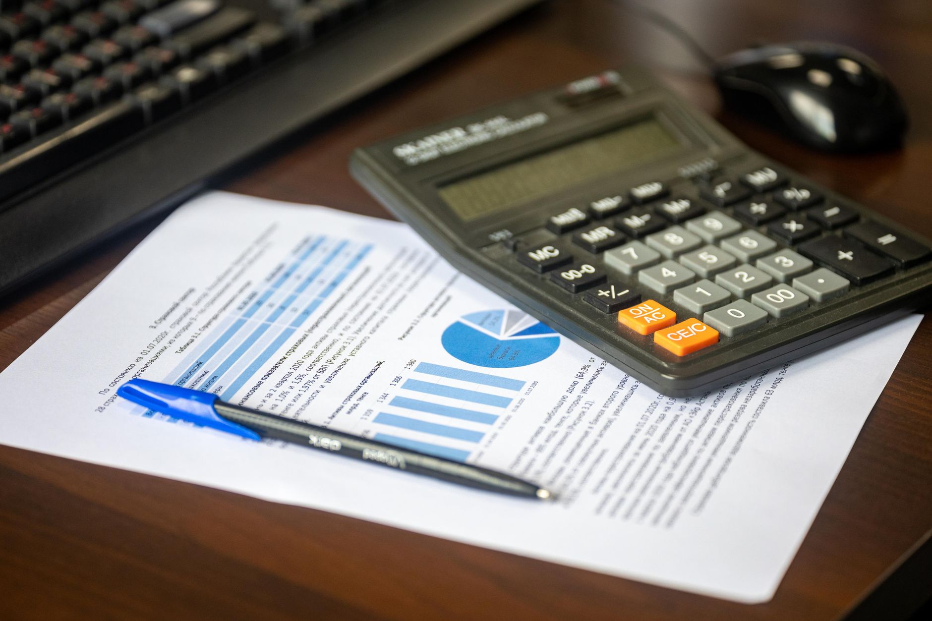 A desk with calculator and financial documents